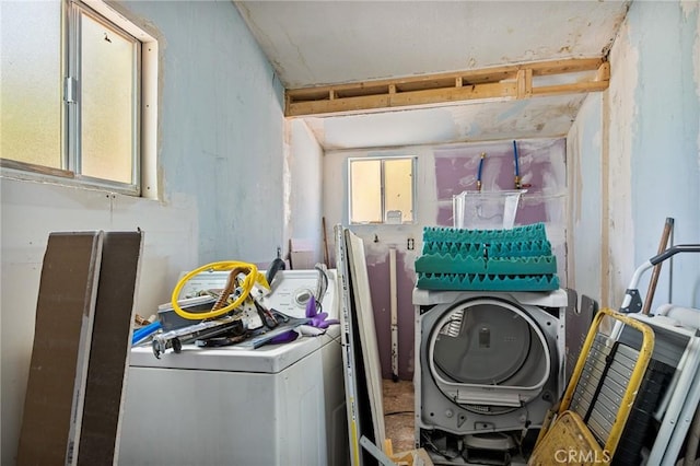 clothes washing area featuring washer / dryer and a wealth of natural light