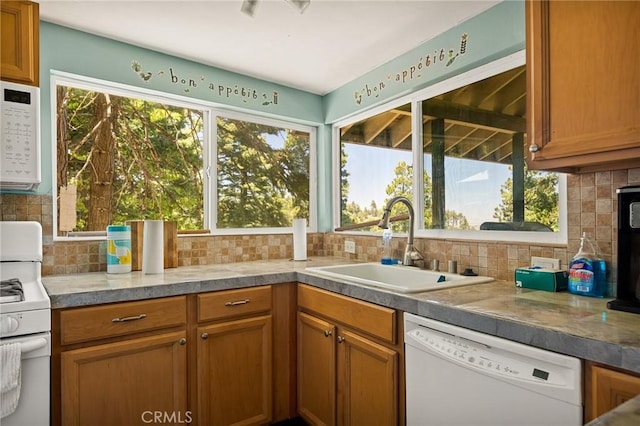 kitchen with white appliances, sink, and tasteful backsplash