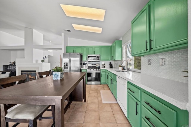 kitchen featuring sink, vaulted ceiling, appliances with stainless steel finishes, and green cabinets