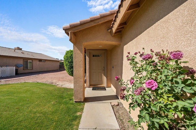 view of exterior entry featuring a yard