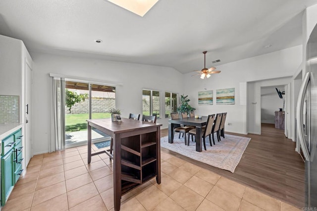 dining area with ceiling fan, lofted ceiling, and light wood-type flooring