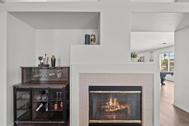 room details featuring hardwood / wood-style flooring and a tiled fireplace