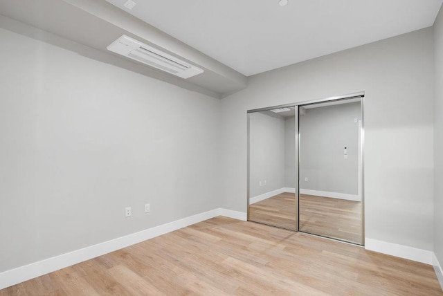 unfurnished bedroom with light hardwood / wood-style floors and a closet