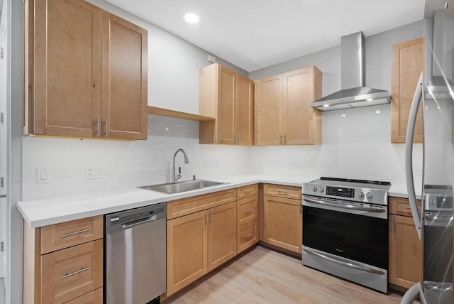 kitchen featuring wall chimney range hood, stainless steel appliances, backsplash, sink, and light wood-type flooring