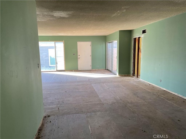 unfurnished room featuring a textured ceiling