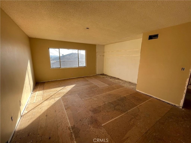 unfurnished room featuring a textured ceiling