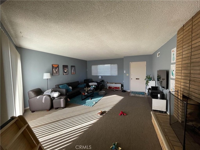 living room featuring a textured ceiling, carpet flooring, and a fireplace