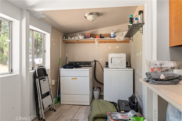 clothes washing area featuring independent washer and dryer, a textured ceiling, and light hardwood / wood-style floors