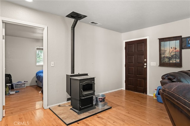 living room with a wood stove and hardwood / wood-style flooring