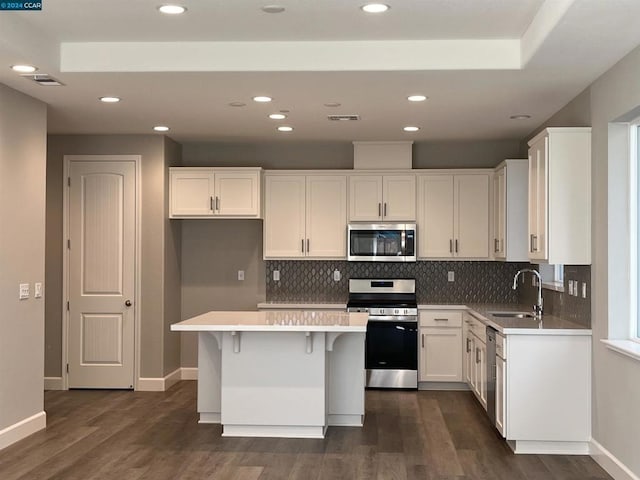 kitchen featuring a center island, white cabinets, sink, dark hardwood / wood-style floors, and stainless steel appliances