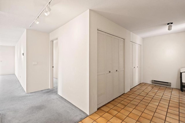 hallway with a baseboard radiator and track lighting