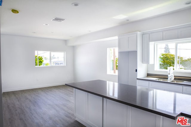 kitchen featuring dark wood-type flooring, sink, and white cabinets