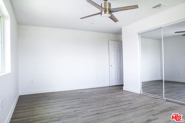 unfurnished bedroom with a closet, ceiling fan, and wood-type flooring