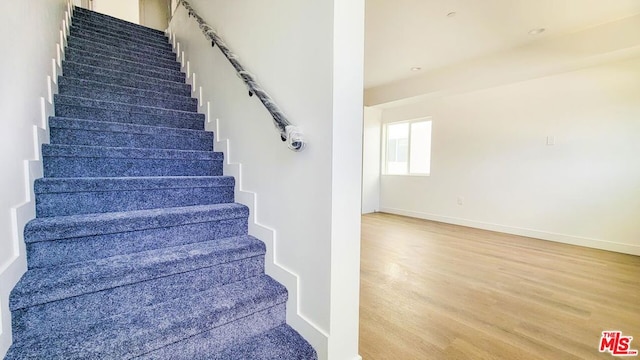 staircase with hardwood / wood-style floors