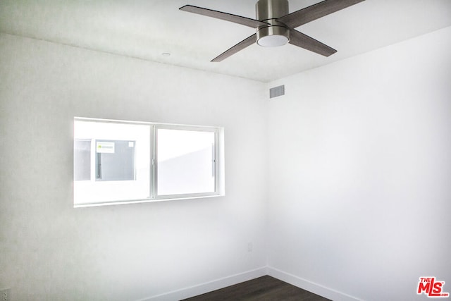 unfurnished room featuring dark wood-type flooring and ceiling fan