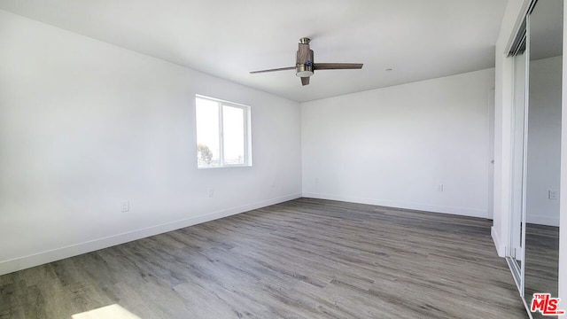 empty room with wood-type flooring and ceiling fan