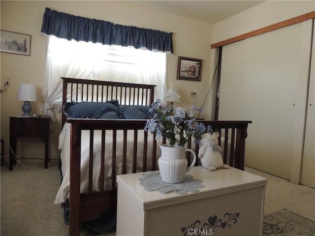 bedroom featuring a closet, light colored carpet, and multiple windows