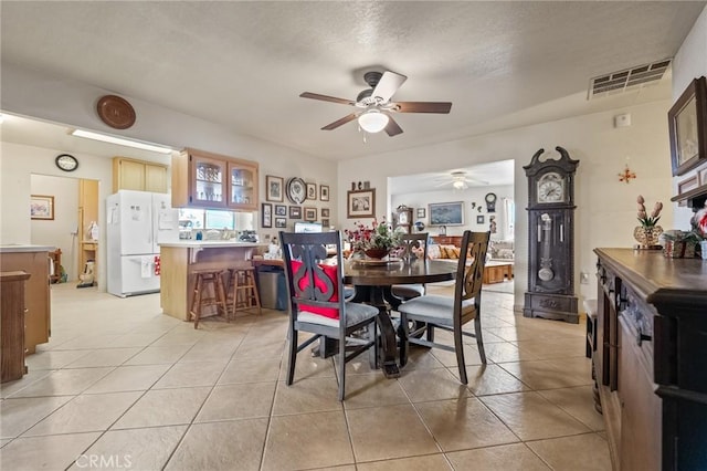 dining space with ceiling fan, light tile patterned flooring, and a textured ceiling