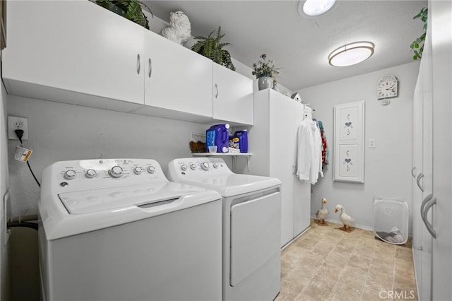 clothes washing area featuring separate washer and dryer and cabinets