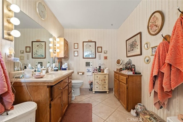 bathroom with toilet, vanity, and tile patterned flooring