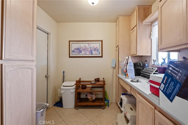 interior space with light tile patterned floors and light brown cabinets