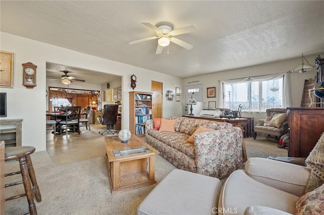 carpeted living room featuring a textured ceiling and ceiling fan