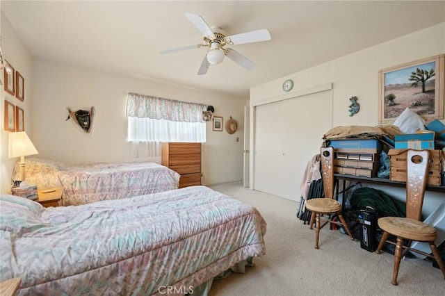 carpeted bedroom with ceiling fan and a closet