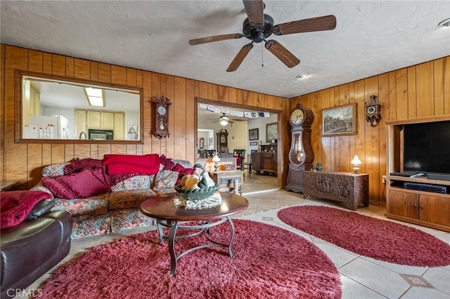 living room with a textured ceiling, light tile patterned flooring, and wooden walls