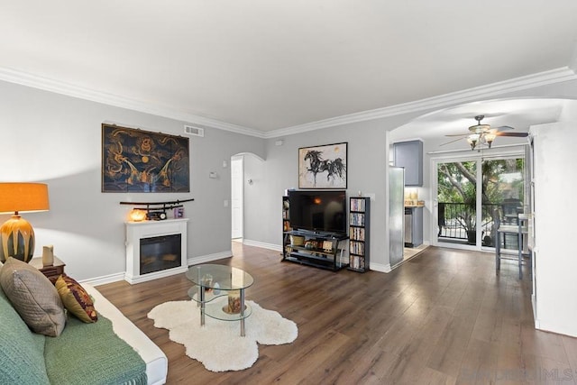 living room with ornamental molding, ceiling fan, and dark hardwood / wood-style flooring