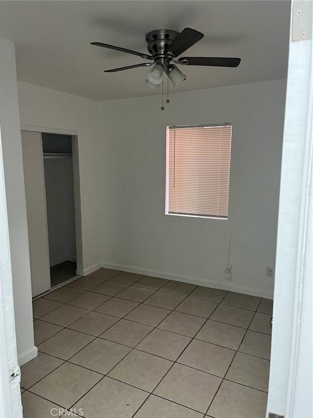 unfurnished bedroom with ceiling fan, light tile patterned floors, and a closet