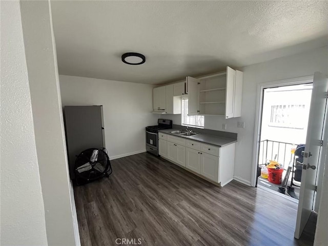 kitchen with a wealth of natural light, dark wood-type flooring, sink, white cabinets, and stainless steel stove