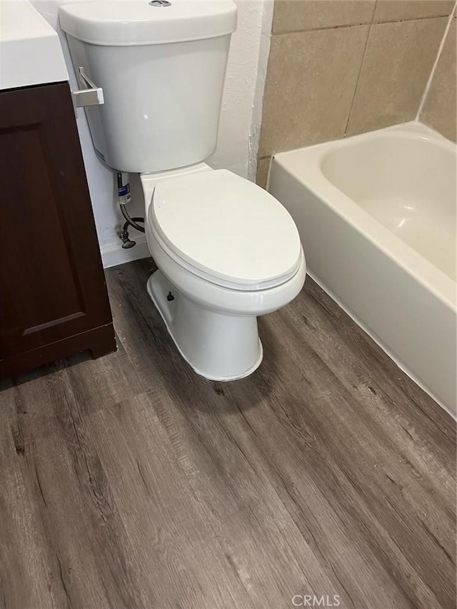 bathroom featuring wood-type flooring, vanity, and toilet