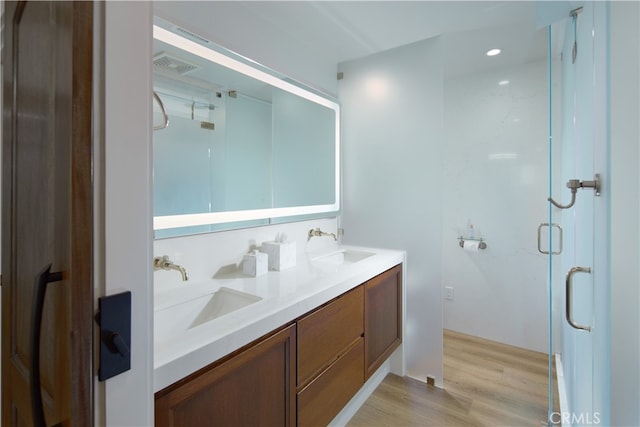 bathroom with a shower with door, vanity, and wood-type flooring