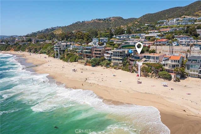 drone / aerial view featuring a water and mountain view and a view of the beach