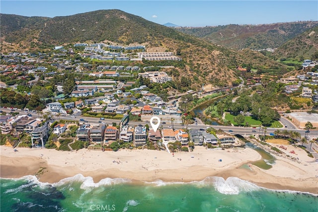 birds eye view of property with a water and mountain view and a beach view