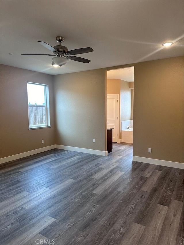 spare room featuring dark hardwood / wood-style flooring and ceiling fan