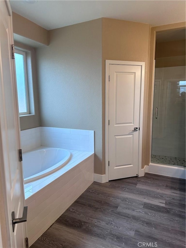 bathroom with plus walk in shower and wood-type flooring