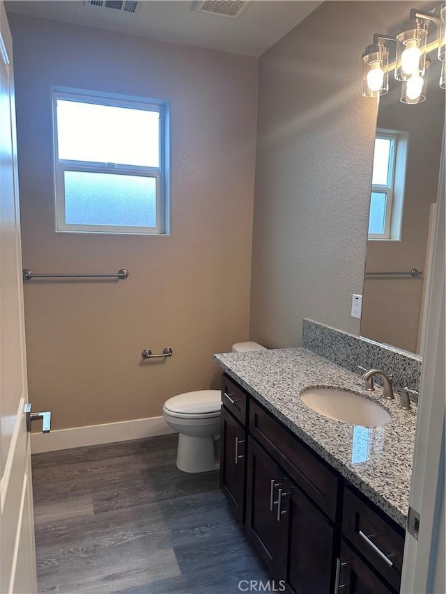 bathroom with vanity, toilet, and wood-type flooring