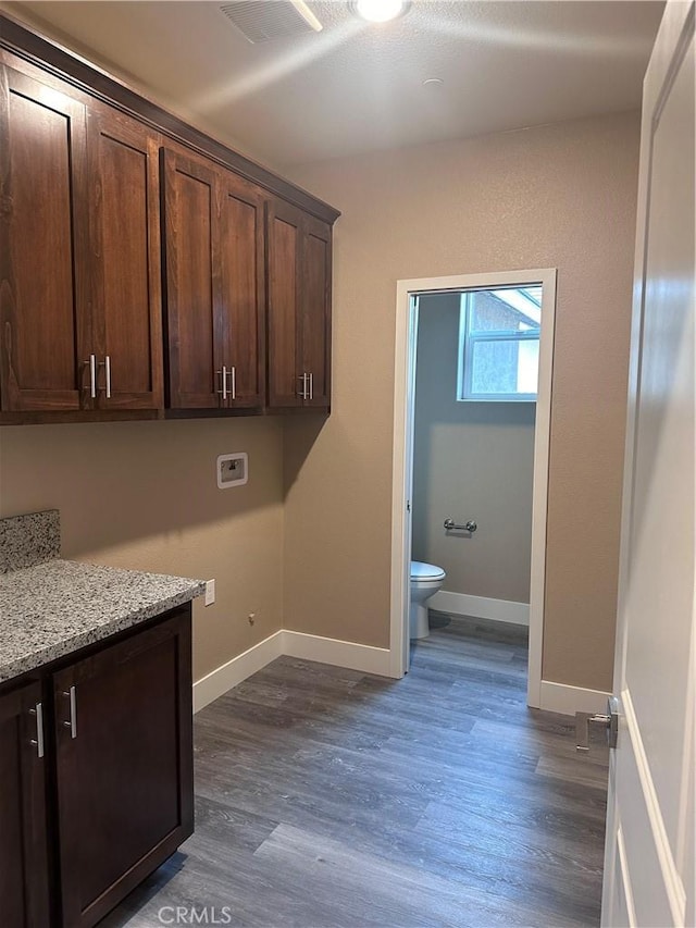 clothes washing area with washer hookup, dark hardwood / wood-style floors, and cabinets