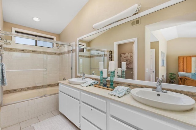 bathroom with tile patterned floors, vanity, vaulted ceiling, and enclosed tub / shower combo