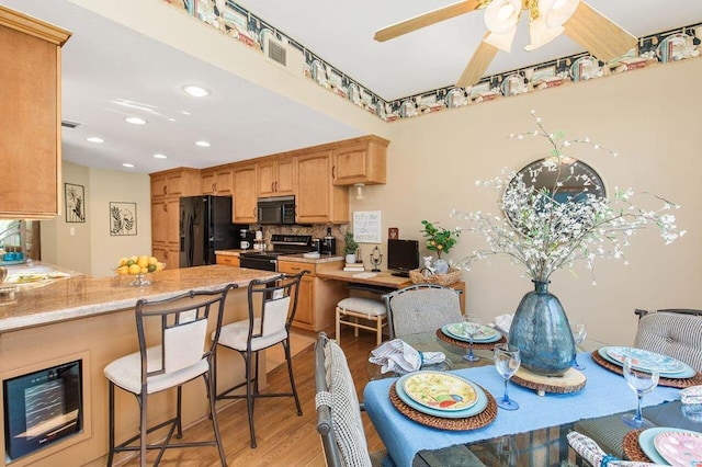 kitchen with ceiling fan, backsplash, kitchen peninsula, black appliances, and light wood-type flooring