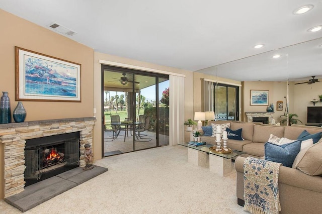 carpeted living room featuring ceiling fan and a fireplace