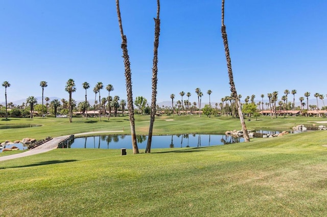 view of home's community featuring a lawn and a water view