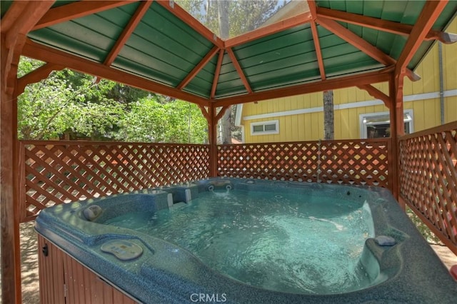 wooden deck with a gazebo and a hot tub