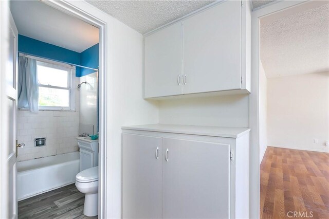 13115 Davenport St, North Edwards, CA 93523 - full bath with a textured ceiling, wood finished floors, toilet, and bathing tub / shower combination