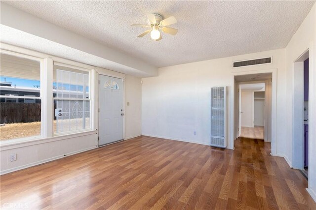 13115 Davenport St, North Edwards, CA 93523 - unfurnished room with a heating unit, a textured ceiling, wood finished floors, ceiling fan, and baseboards