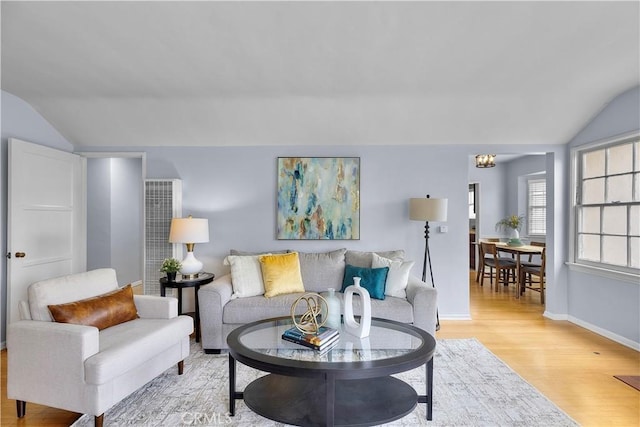 living room with light hardwood / wood-style floors and vaulted ceiling