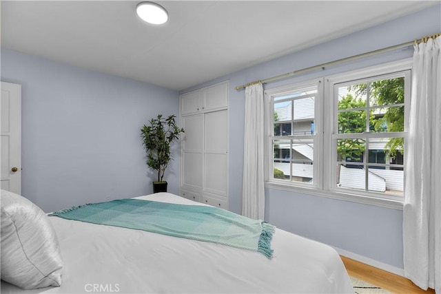 bedroom with light hardwood / wood-style flooring and a closet