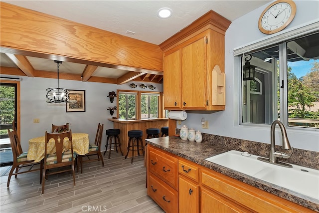 kitchen with sink, beam ceiling, and pendant lighting