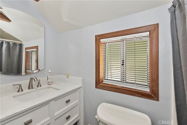 bathroom featuring a healthy amount of sunlight, vanity, and toilet